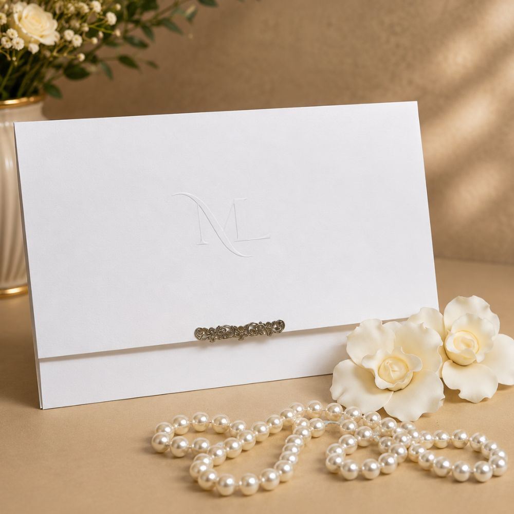 Convite de Casamento com Monograma e Ponteira Prata 2 Convite de casamento branco com monograma em relevo seco e ponteira metálica prata.